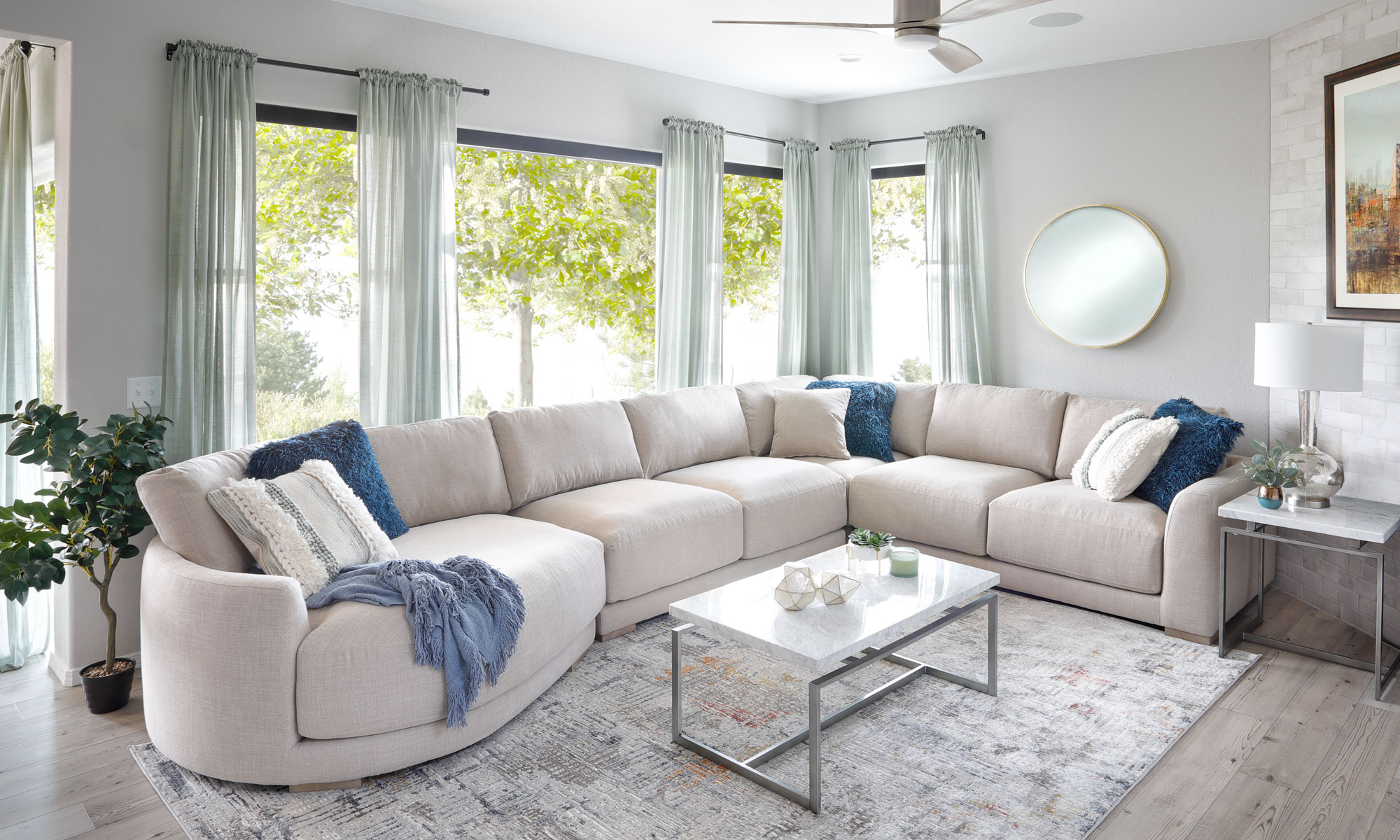 White curvy fabric sectional with blue accent pillows 