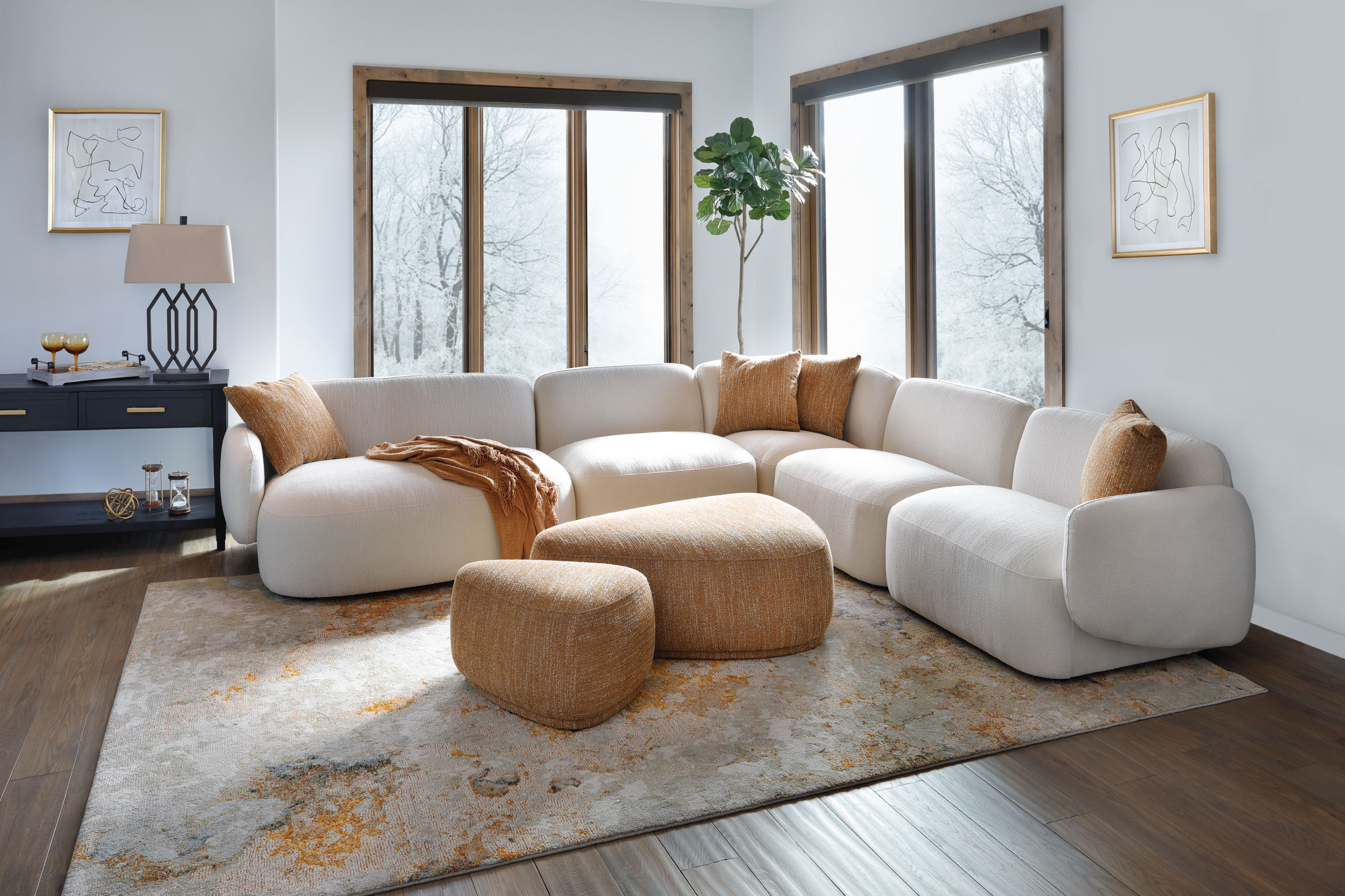 White curved sectional with gold pillows and gold geometric shaped ottomans