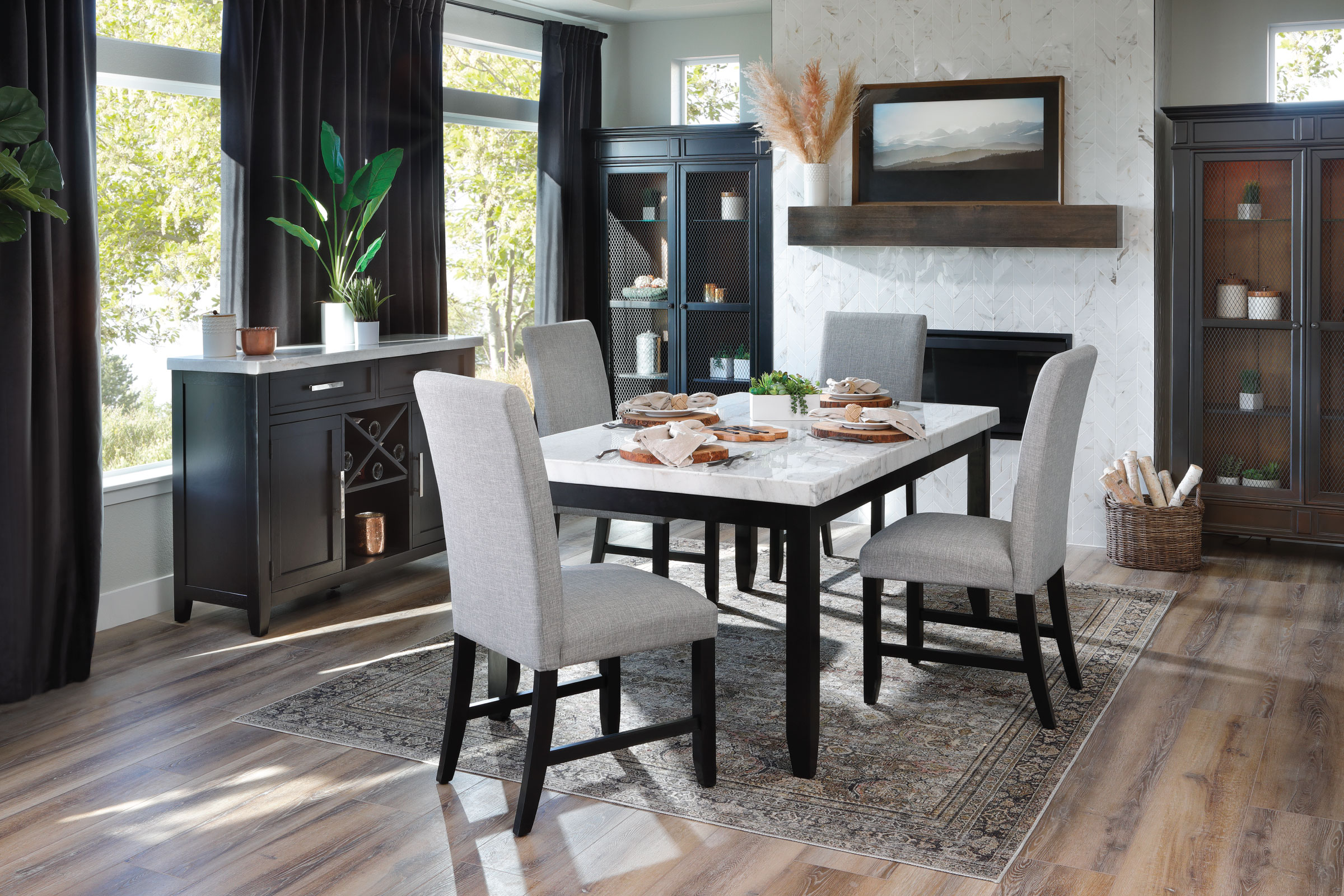 White Marble top dining table with black wood base and light gray fabric parsons chairs. 