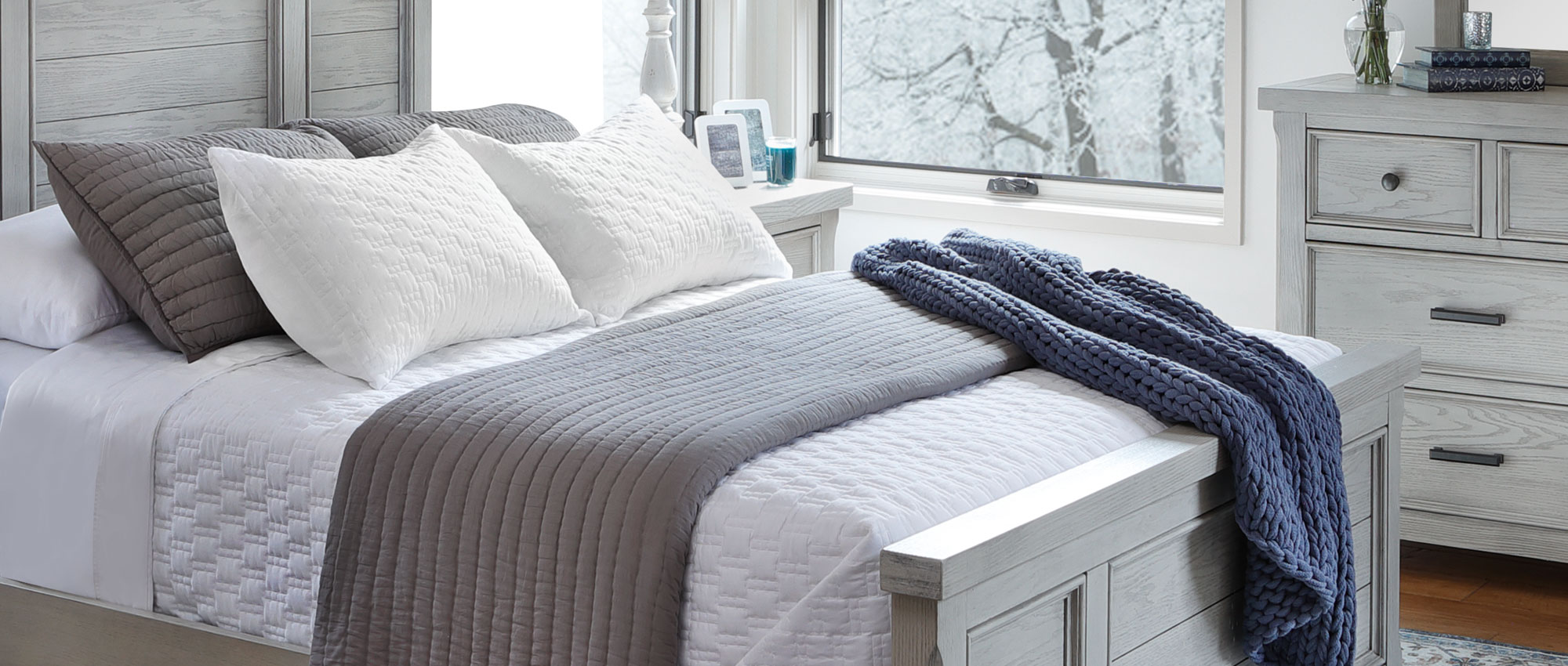 Bedroom During Winter With a Blue Double Knit Throw Blanket Draped over Bed